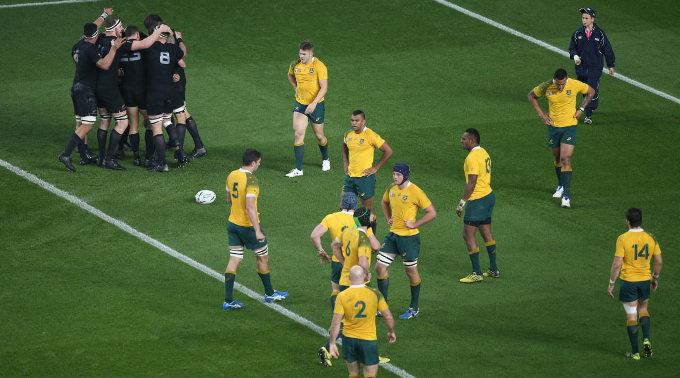 Die Neuseeländer feiern, während Australiens Spieler niedergeschlagen auf dem Spielfeld herumstehen.